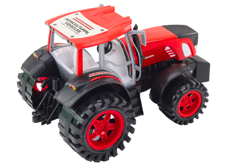 Velký zemědělský traktor s přívěsem a balíky sena červený